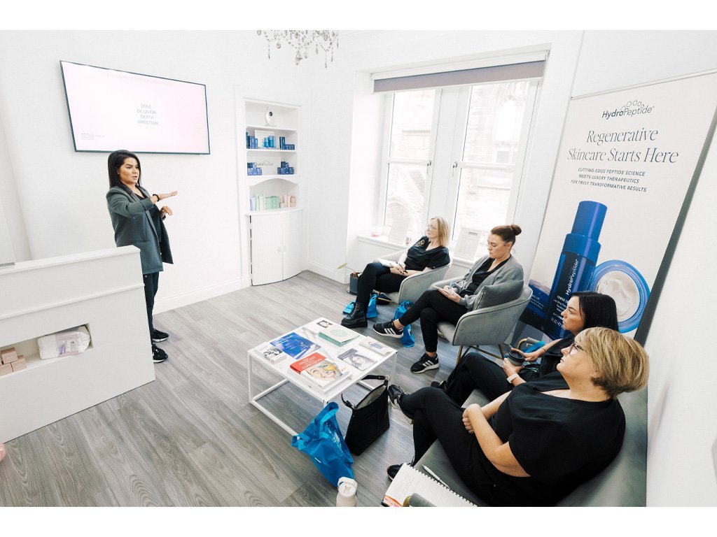 Dr Lauren addressing students about safety and ethics in facial aesthetics procedures.