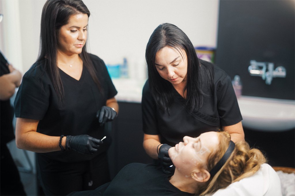 A student learning directly from Dr Lauren how to inject fillers safely.