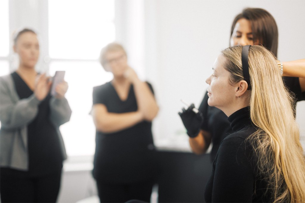 Dr Lauren teaching her students how to map out where to inject fillers in a patient's face.