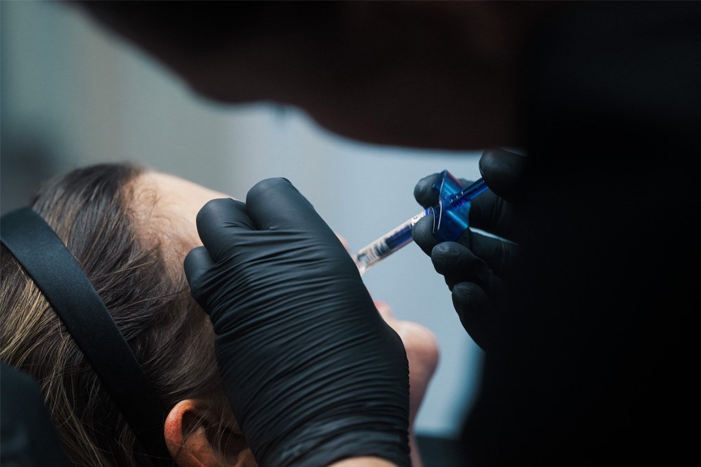 Dr Lauren demonstrating how to safely deliver aesthetic treatments to students at the ATA.
