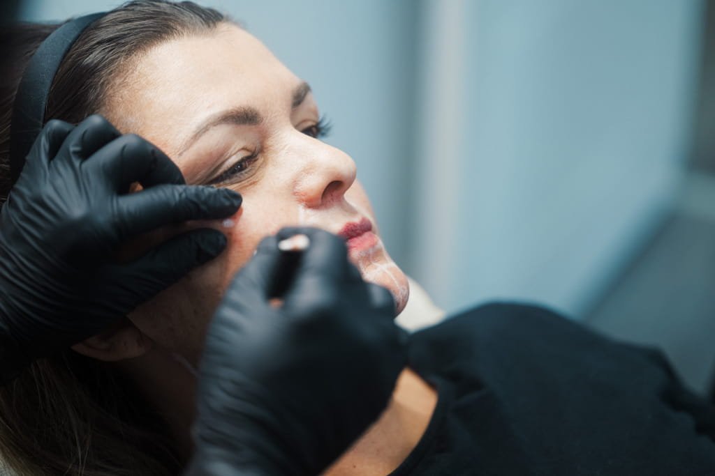 Dr Lauren mapping out the facial anatomy on a patient's face.